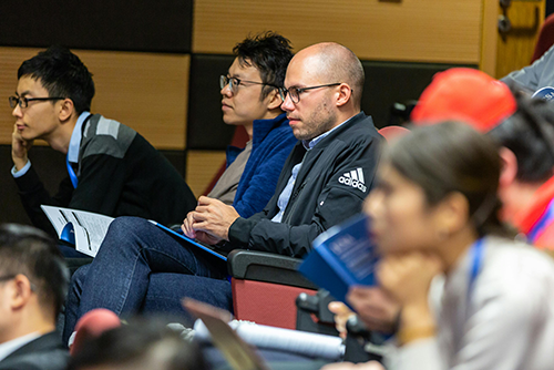 Man listening to a presentation in full room