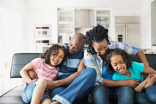 Family laughing on couch