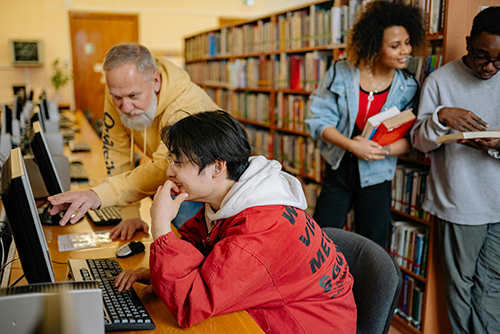 Professor working with student on computer