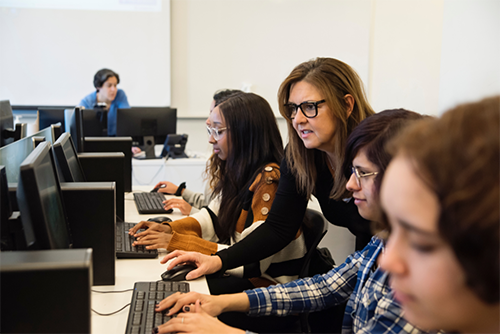 Teacher working with student on computers