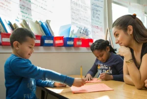 Teacher watching a student complete work