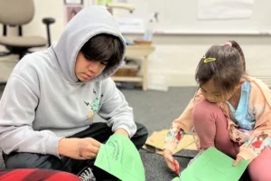 Two kids cutting out paper